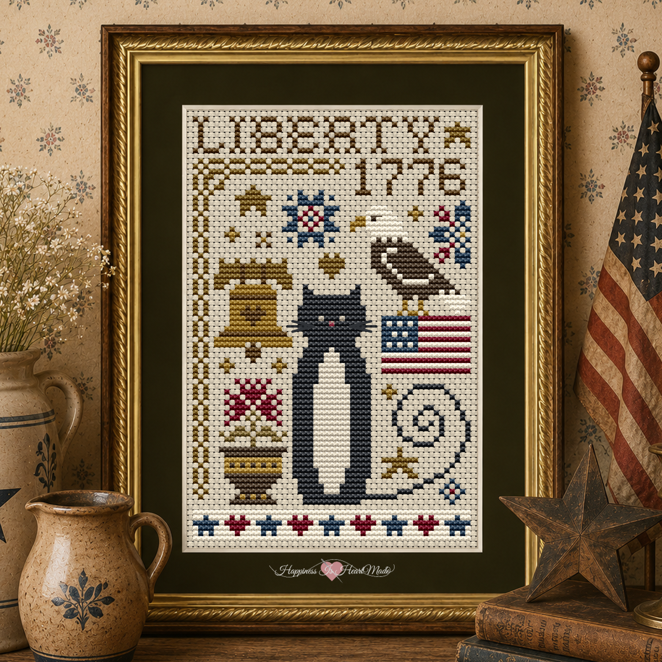 Liberty Cat Cross Stitch Pattern 5587 from the Cat Tales Collection by Happiness Is HeartMade. Designer Christy Shuhy Ortiz. A patriotic counted cross stitch pattern with Liberty 1776 stitched across the top. A tuxedo cat is surrounded by an American Bald Eagle, the USA flag, the Liberty Bell, flowers, stars, hearts, and other motifs. A beautiful design to stitch for Independence Day.